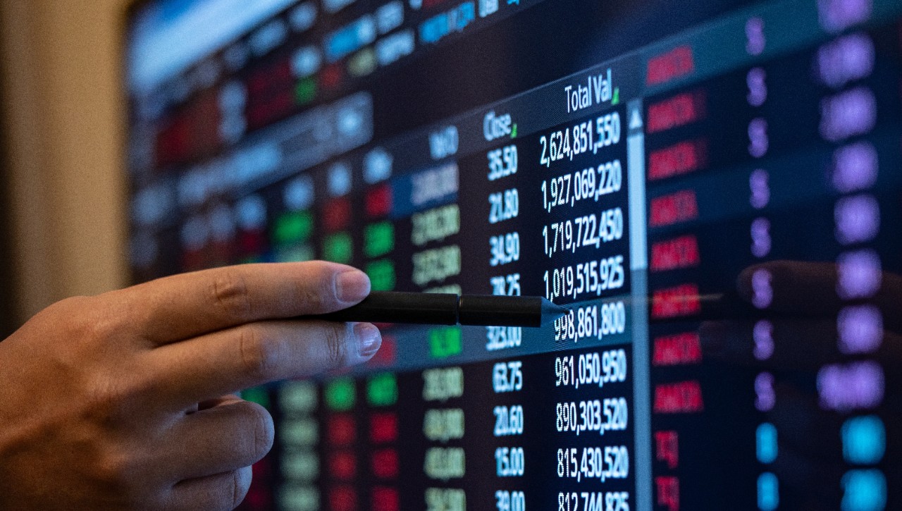 Hand of a stockbroker looking at shares online